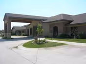 Arborview Court senior living facility exterior with a covered entrance and circular landscaped drive.
