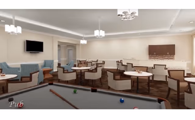 Interior view of a recreational lounge area with a pool table in the foreground, multiple round tables with chairs arranged around the room, a wall-mounted TV, and modern ceiling lights.