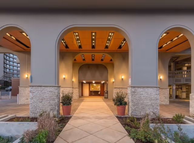 Exterior entrance of Calaroga Terrace with arched doorway, stone columns, and illuminated walkway.