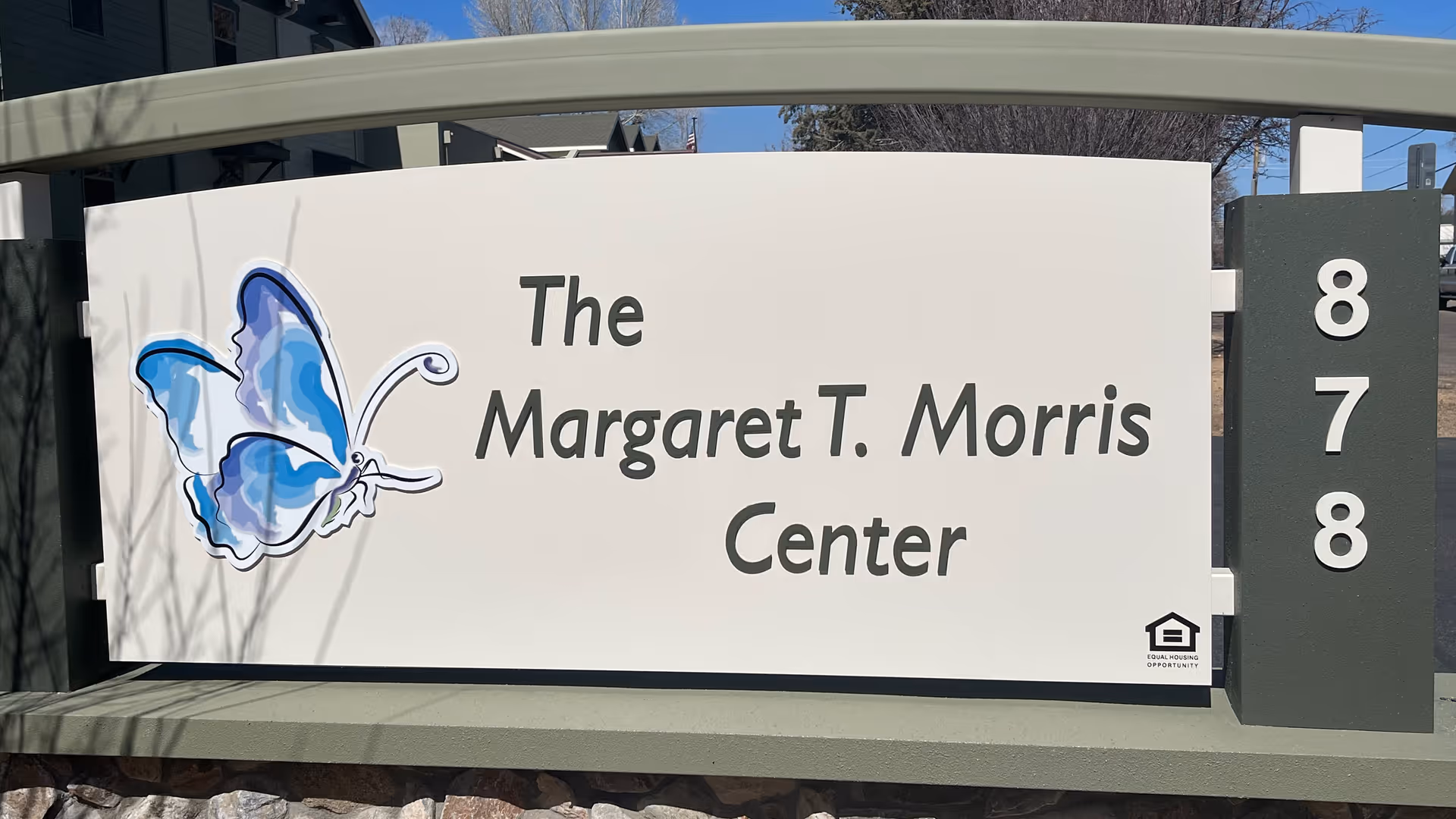 Outdoor sign for The Margaret T. Morris Center featuring a blue butterfly graphic and the address number 878 on a post to the right.