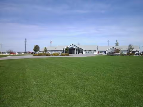 Front view of Country Aire Retirement Estate with a green lawn and clear sky.