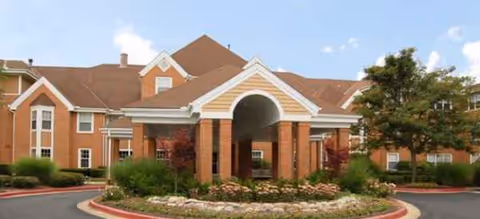 Exterior view of Brookdale Montrose, a brick senior living facility entrance with landscaped circular drive.