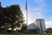 Capital Manor Retirement Community entrance sign with flagpole and building in background.