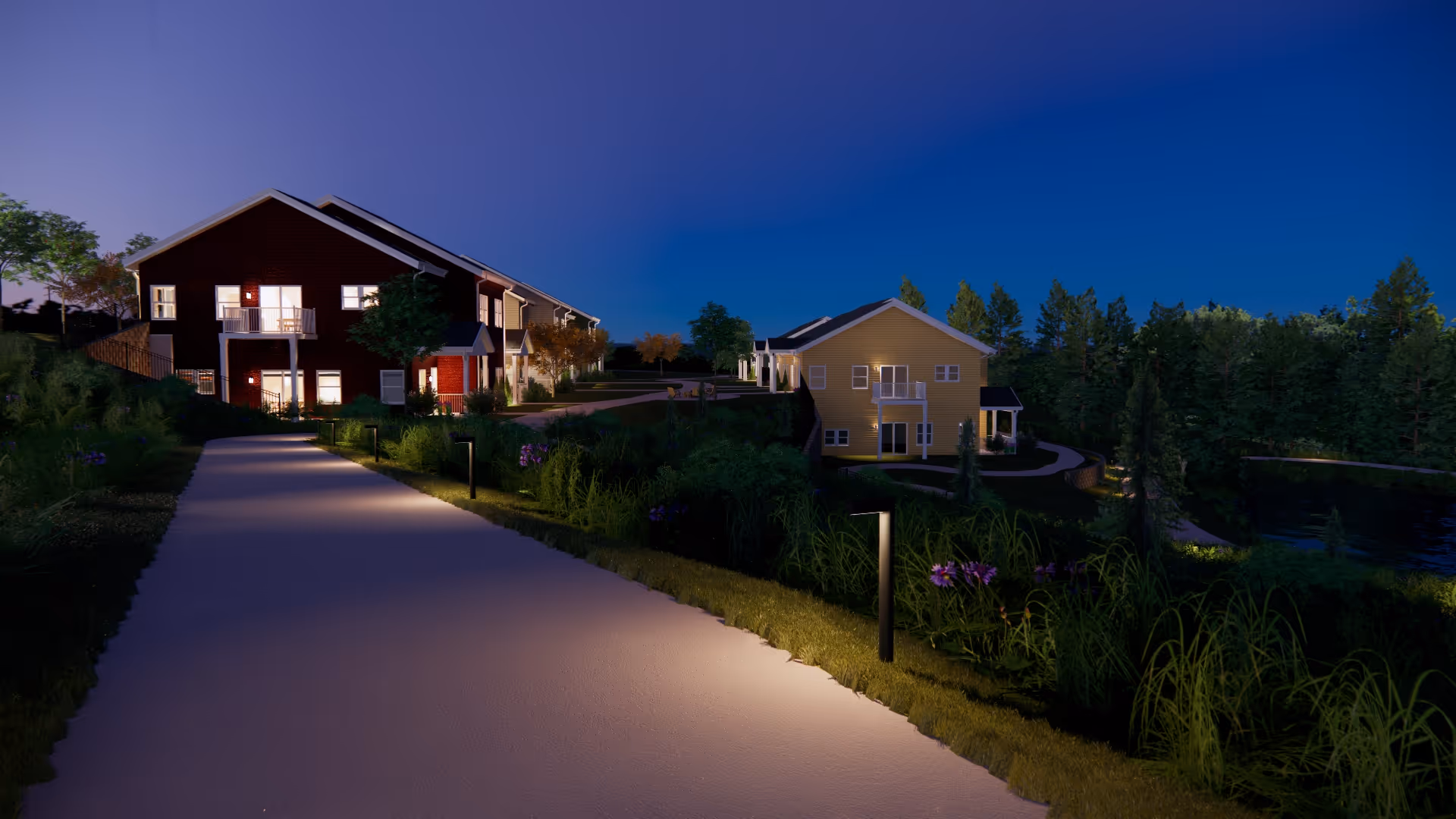 Nighttime view of a senior living facility with a paved walkway lit by ground lights, leading past two residential buildings surrounded by greenery and trees, with a pond visible on the right side.