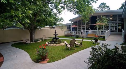 Cardinal Care of Jacksonville outdoor courtyard with a fountain, chairs, and a covered patio.
