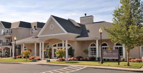 Front view of Truewood by Merrill Vancouver senior living facility with columns and landscaped entrance.
