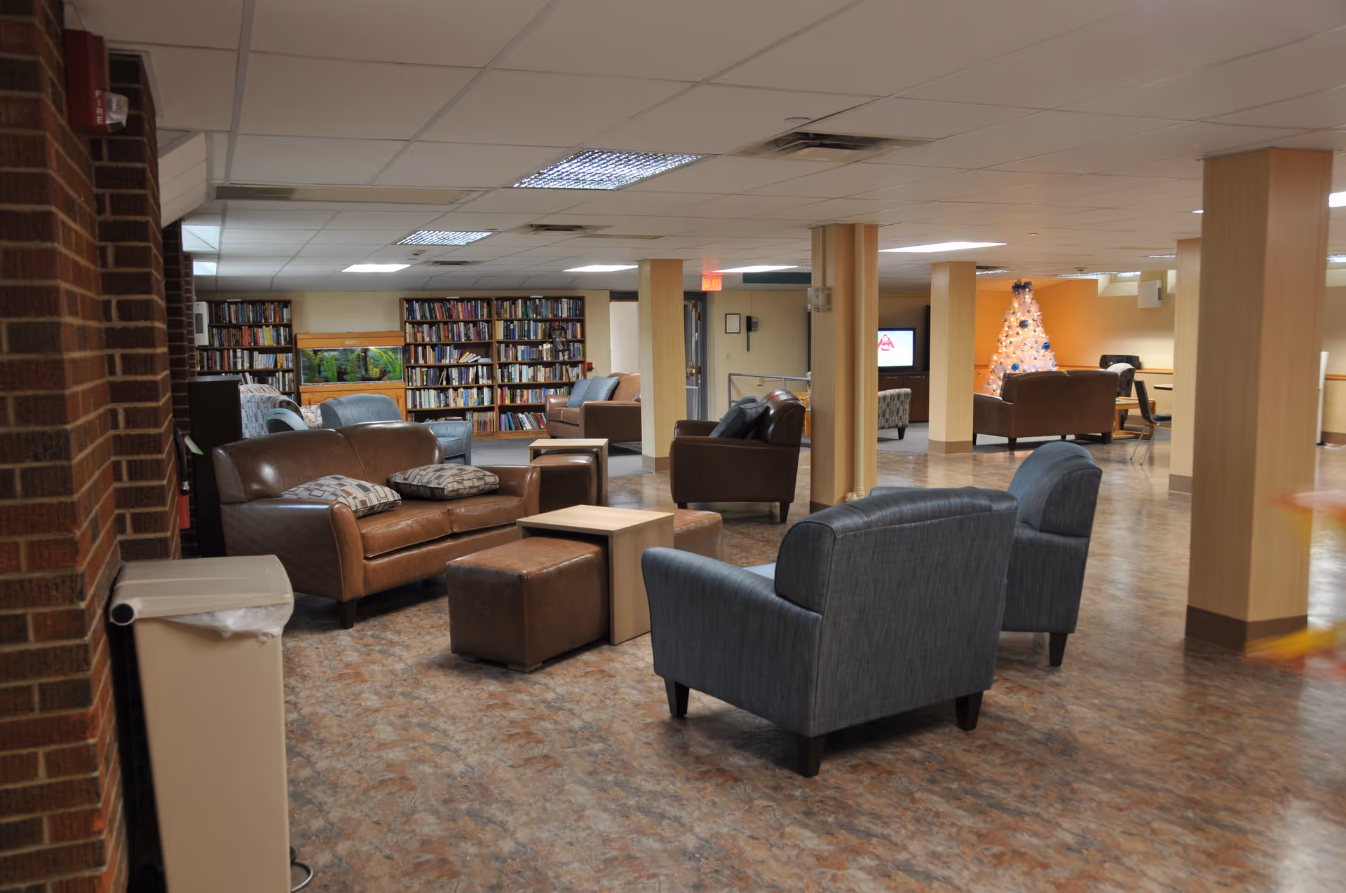Interior common area of Pleasant Ridge Manor with seating and a bookshelf.