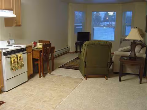 Open-concept living area featuring a kitchen, dining table, and seating.