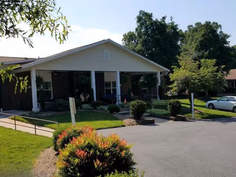 Front entrance of Brockford Inn senior living facility with landscaping and a driveway.