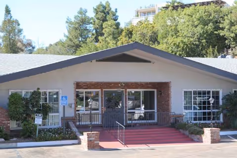 Front entrance of Mission Hills Post Acute Care with red steps and glass doors.