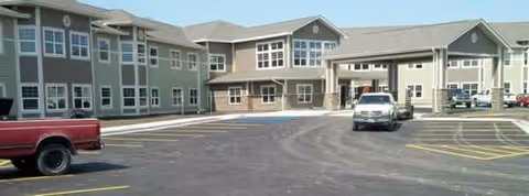 Exterior view of Edgewood Bismarck Village with parking lot and covered entry.
