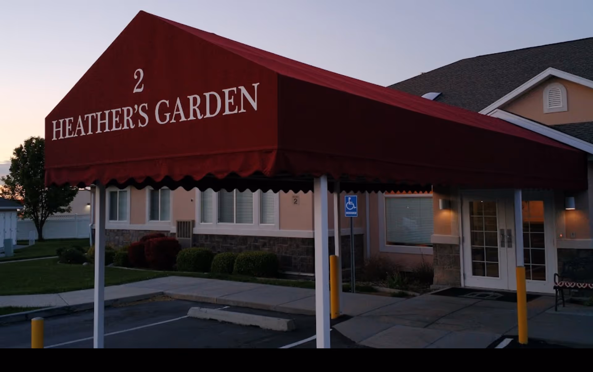 Entrance to Heather's Garden at Cottage Glen Assisted Living, featuring a maroon canopy.
