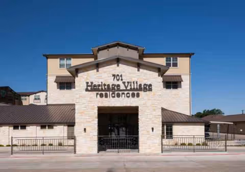 Front view of Heritage Village Residences building with stone facade and welcoming entrance.