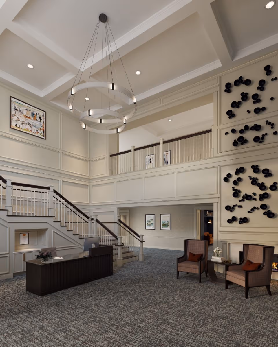 Spacious two-story interior lobby with a reception desk, central staircase, seating area, and a modern circular chandelier.