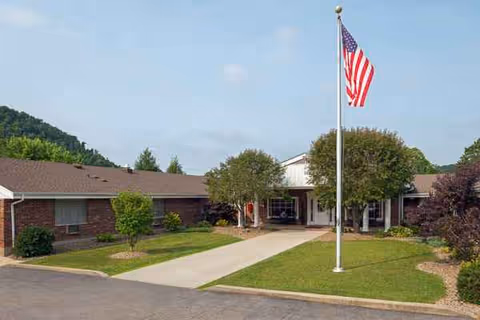 Exterior view of Life Care Center of Morehead with flagpole and landscaped entrance.