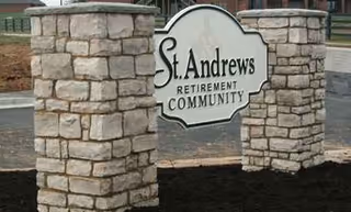 Stone entrance sign reading St. Andrews Retirement Community between two stone pillars.