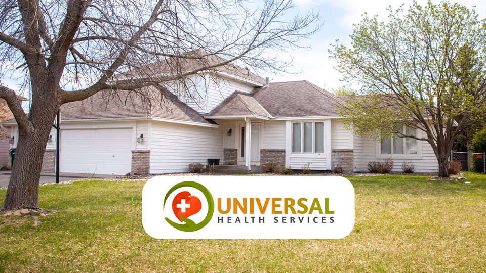 Suburban single-family house with an attached garage and front lawn, overlaid with a Universal Health Services logo.