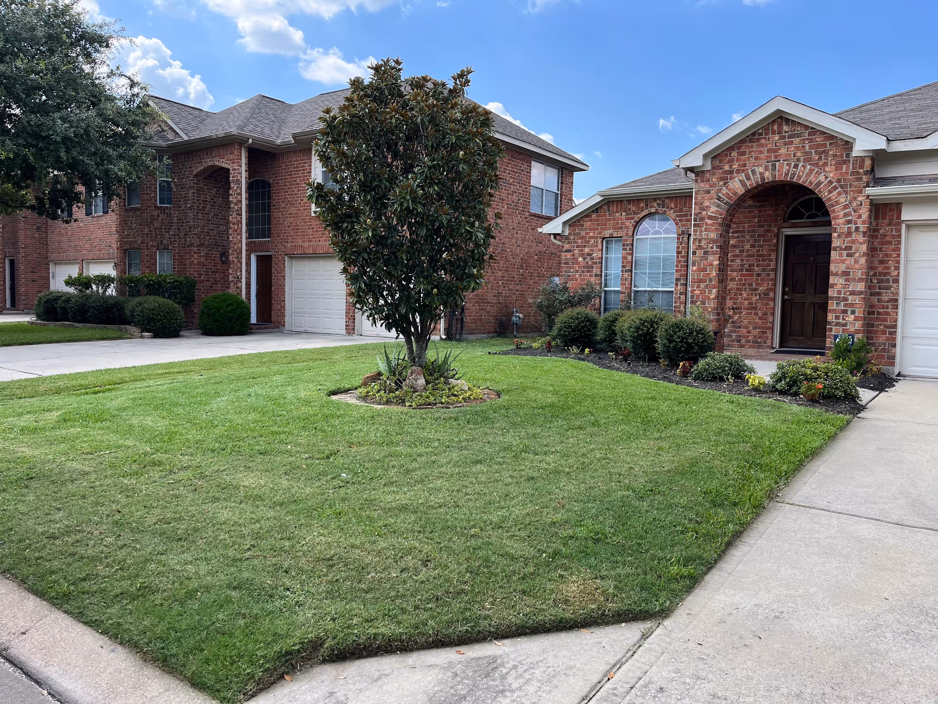 Exterior view of a brick Avista Living building with manicured lawn and arched entrance.