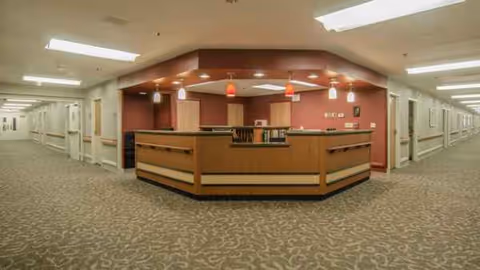 central reception desk in a spacious hallway with patterned carpet and warm lighting