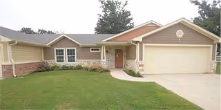 Front view of Oak Wood Place Assisted Living facility with driveway and garage.
