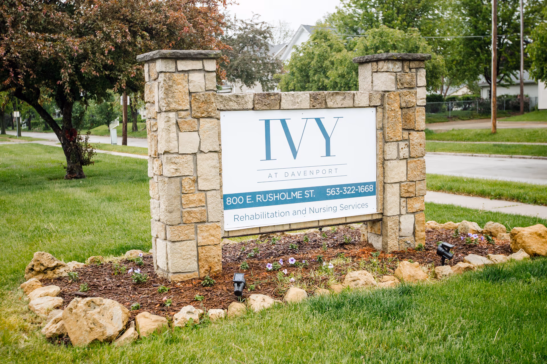 Stone-framed monument sign reading IVY at Davenport with address and phone number in a landscaped grassy area.
