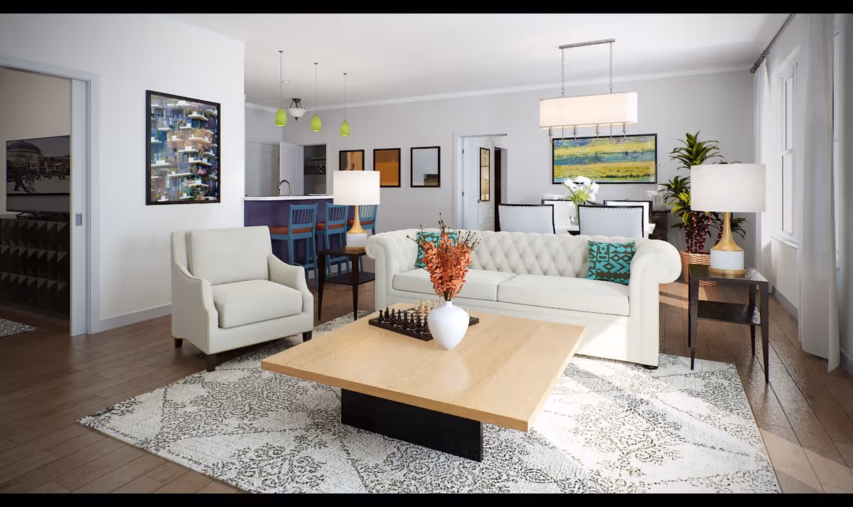 A bright and spacious living room with a white tufted sofa, a beige armchair, a wooden coffee table with a white vase and a chessboard, two side tables with lamps, a patterned area rug, and large windows with curtains letting in natural light. In the background, there is a dining area with a table and chairs, colorful artwork on the walls, and a kitchen with bar stools and pendant lights.