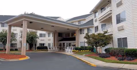 Exterior view of Haywood Estates by Barclay House entrance with covered drop-off and landscaping.