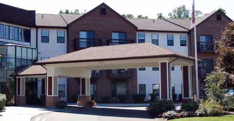 Exterior view of Cedar Woods senior living facility with a covered front entrance.