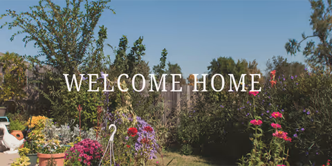 Outdoor garden with colorful flowers and trees, Welcome Home overlay.