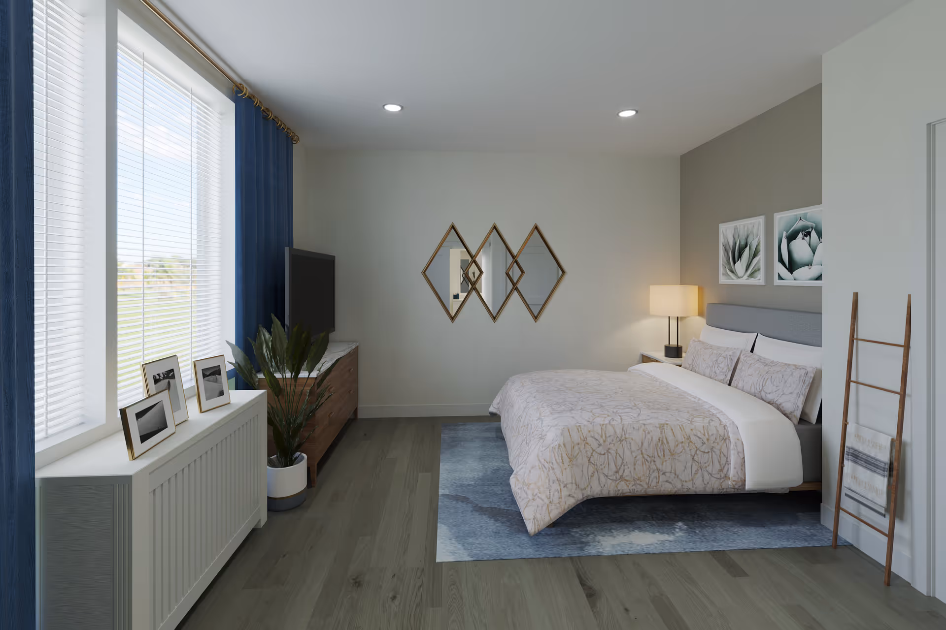 A modern bedroom with a large bed covered in light-colored bedding with a subtle pattern, a blue area rug underneath, and two framed botanical prints on the wall above the headboard. There is a wooden dresser with a flat-screen TV on top, a potted plant beside it, and three framed photos on a white radiator cover near a window with blue curtains. A wooden ladder with a blanket draped over it leans against the wall near the bed. The room has recessed ceiling lights and light gray walls.