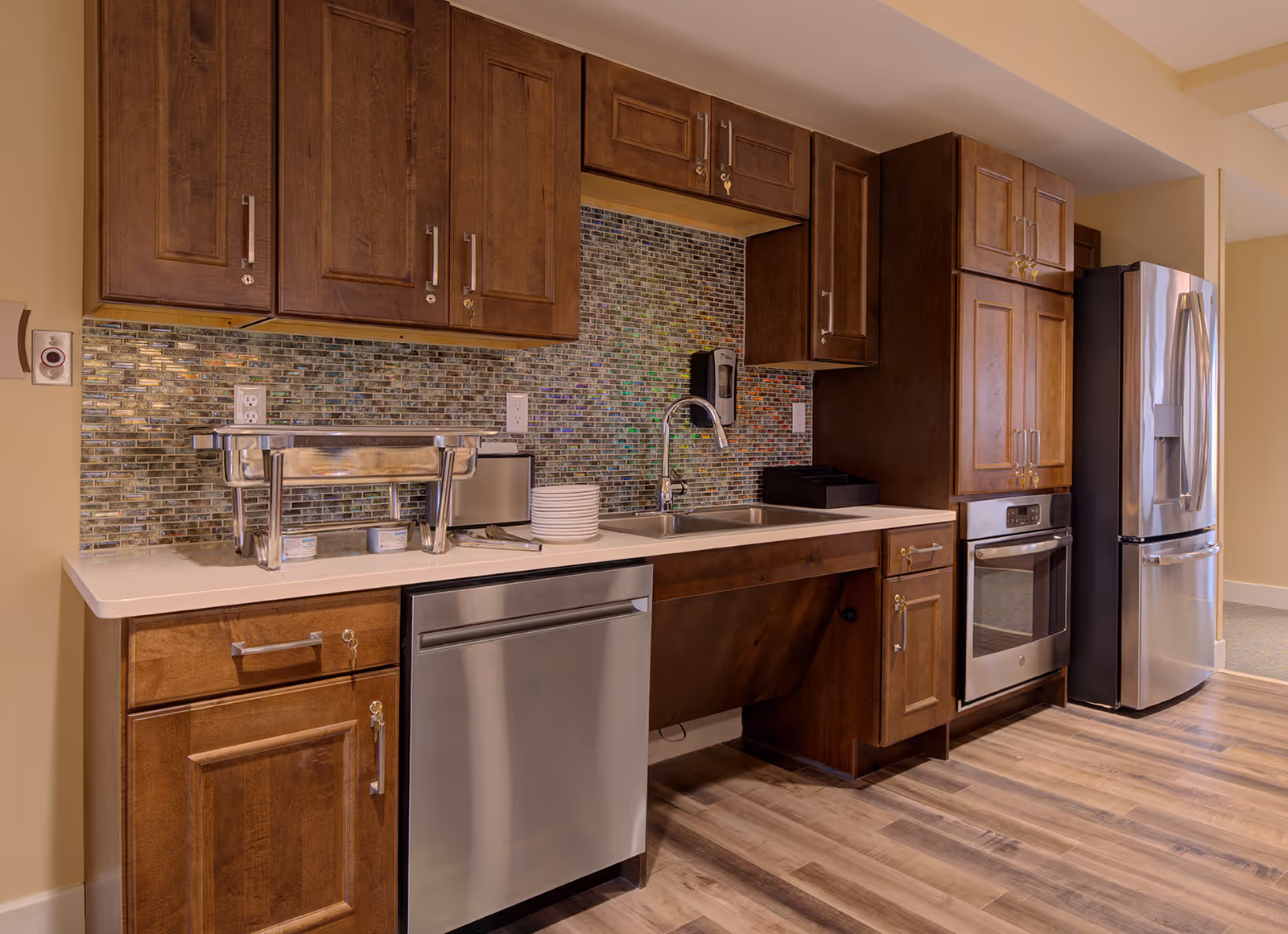 Modern kitchen with dark wooden cabinets, stainless steel appliances, a sink, and a mosaic tile backsplash.
