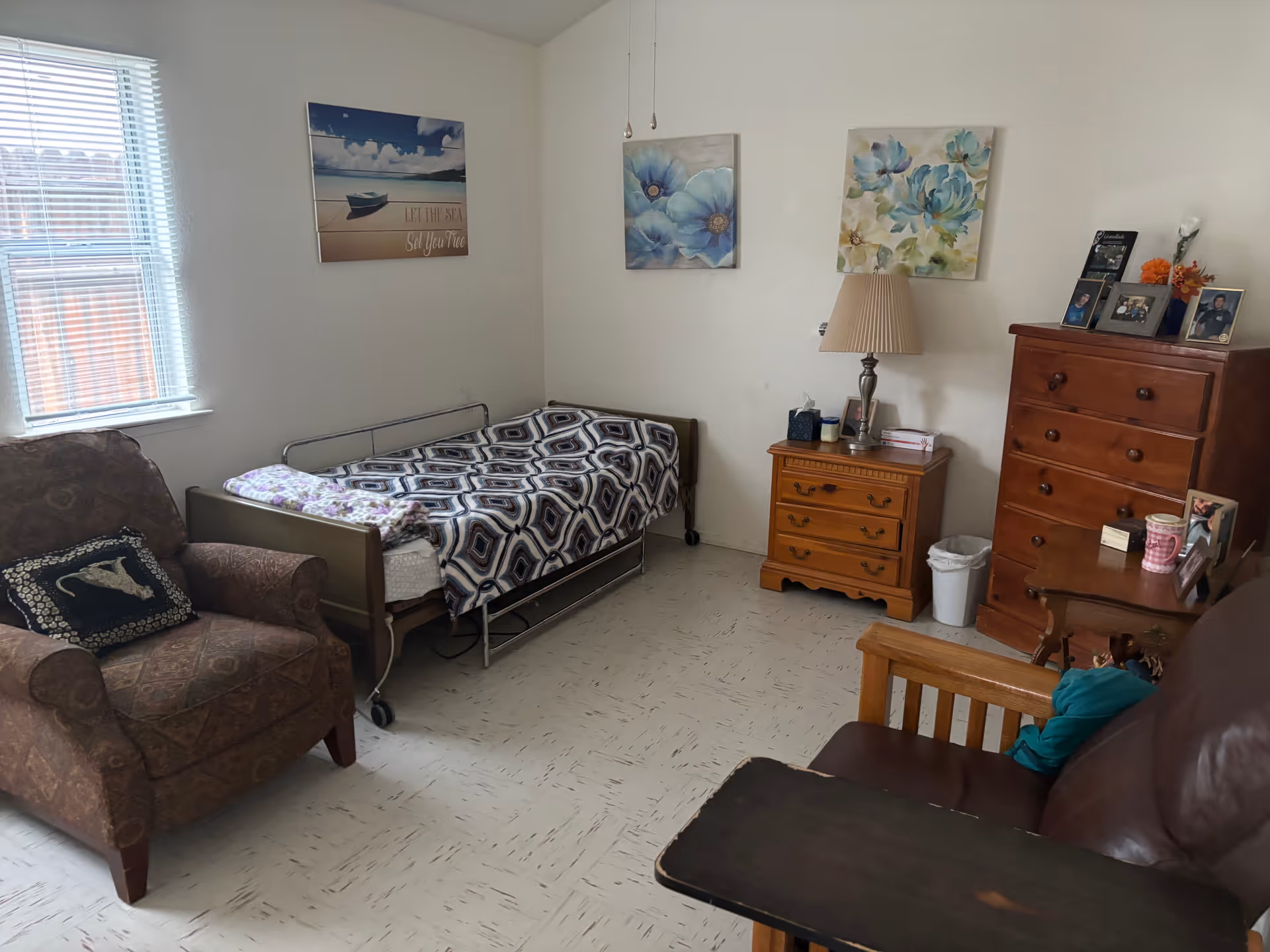 Bedroom in Christina's Care Home with single bed, dresser, chair, and wall art.
