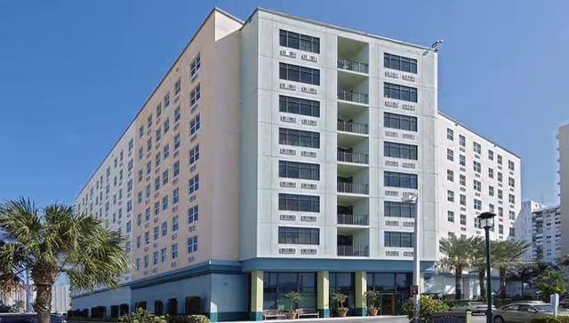 Exterior view of The Sterling Aventura, a multi-story senior living building with balconies.