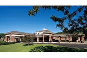 Sugar Creek Care Center exterior with brick facade, central entrance, and green lawn.