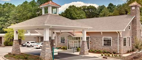 PruittHealth-Elkin facility exterior with brick porte-cochere and parked cars.