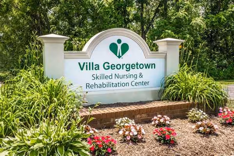 Exterior sign for Villa Georgetown Skilled Nursing & Rehabilitation Center amid landscaped greenery.