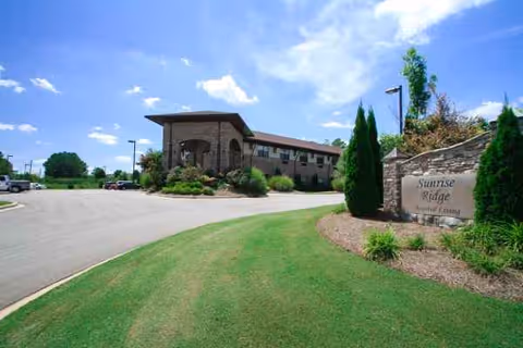 Exterior view of a senior living facility with curved driveway and landscaped entrance.