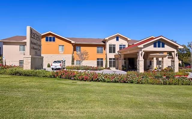 Exterior view of Legend at Tulsa Hills senior living facility with landscaping and entrance.