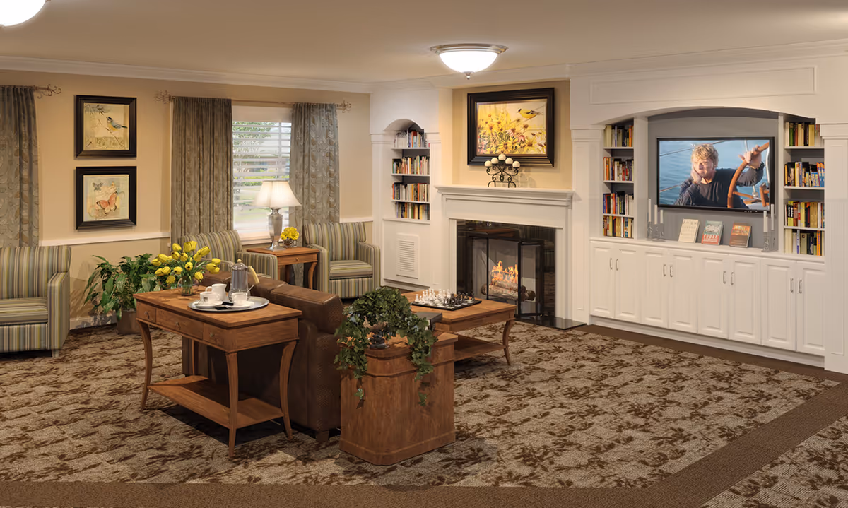 A cozy living room with a brown patterned carpet, a fireplace with a lit fire, and a TV built into white cabinetry surrounded by bookshelves. The room has comfortable striped armchairs, a brown sofa, wooden side tables with a tray holding a coffee set, and decorative plants. Two framed pictures hang on the wall near a window with patterned curtains.