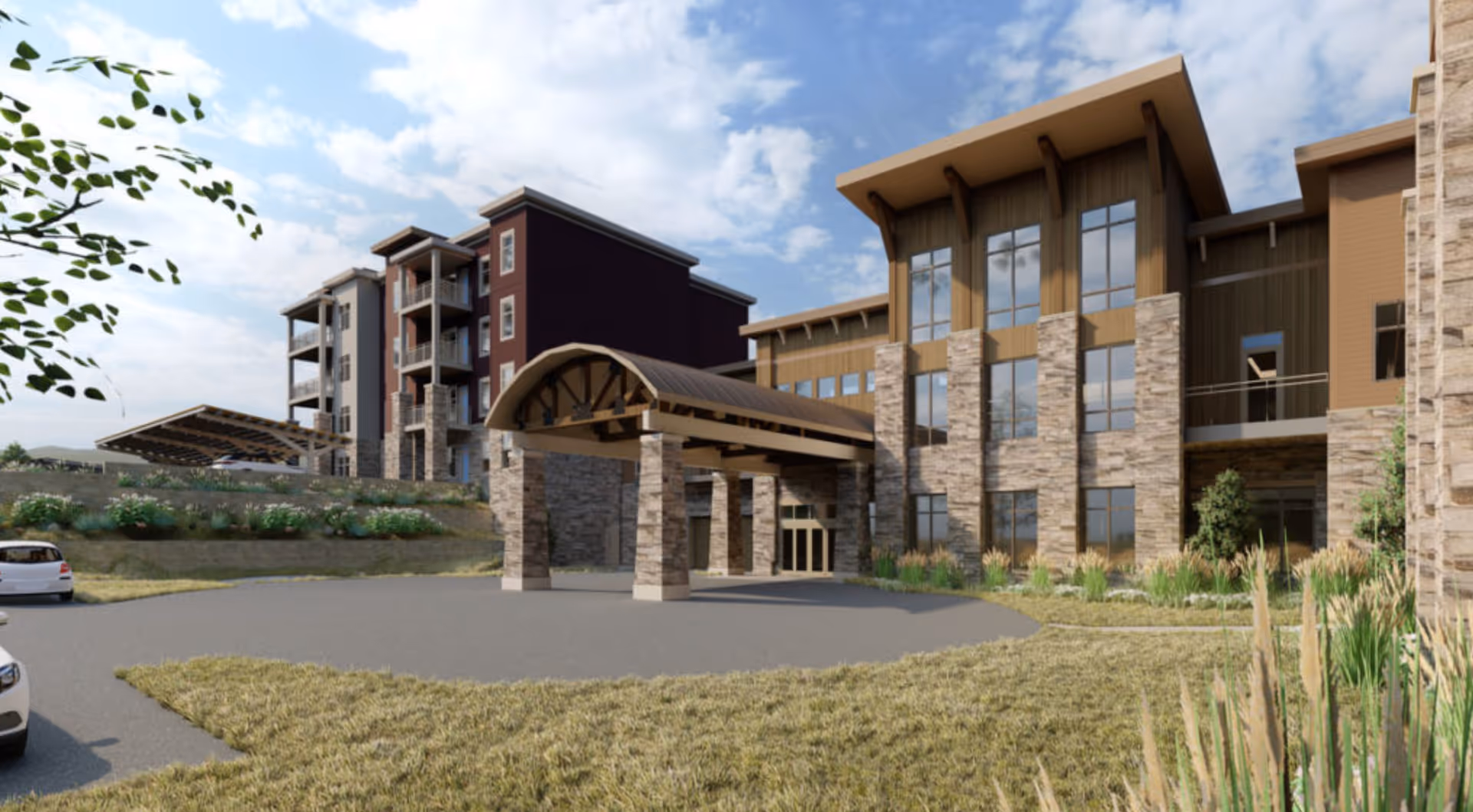 Exterior view of Aberdeen Ridge facility showing a large building with stone and wood facade, a covered entrance supported by stone pillars, landscaped grounds with grass and plants, and a partly cloudy sky.