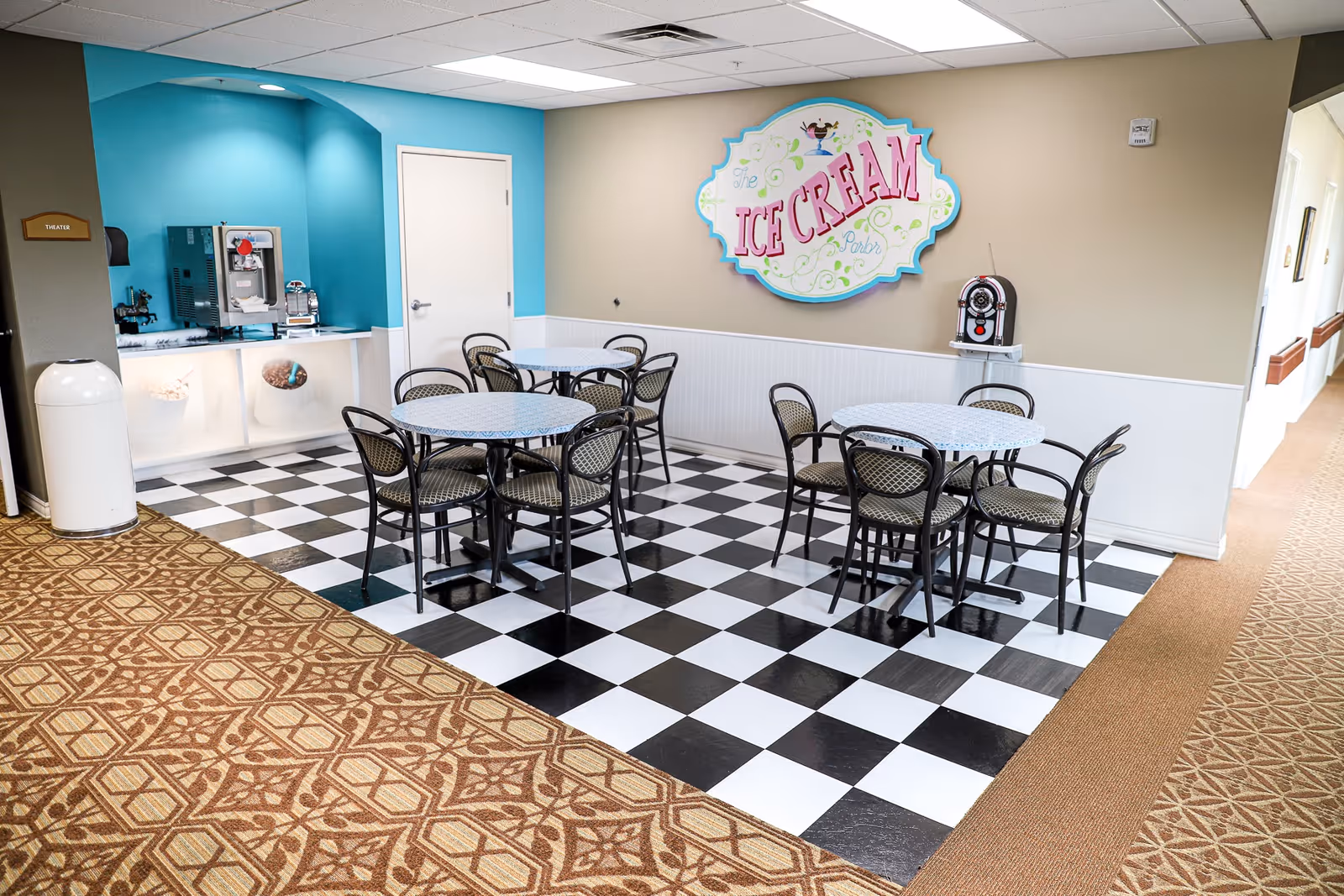Small ice cream parlor seating area with four round tables, black-and-white checkered floor, and an 'Ice Cream' sign on the wall.