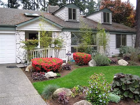 Single-story facility exterior with stone facade, dormer windows, and manicured front landscaping.