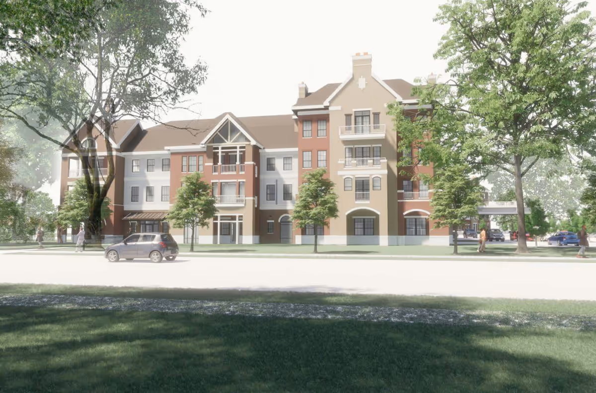 Exterior view of a multi-story senior living facility building named Brookwood Point, surrounded by trees and greenery with a few people walking and cars parked nearby.