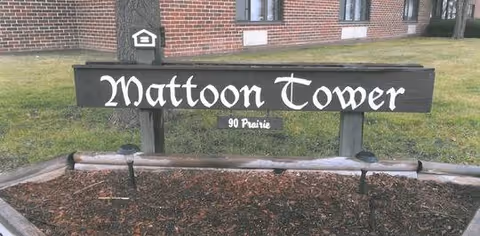 Exterior view of Mattoon Tower sign in front of brick building.