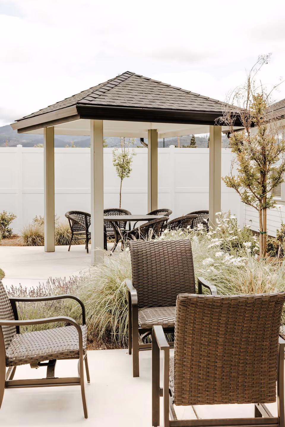 Outdoor courtyard with wicker patio chairs and a small covered gazebo.