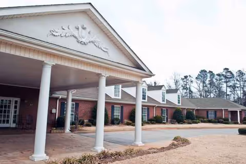 Windsor House Greenville exterior with brick facade, white columns, and covered entrance.