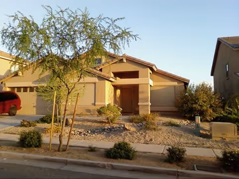 Front exterior view of a single-story assisted living facility with desert landscaping.