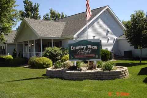 Front view of Country View Estates facility exterior with sign, lawn, and flagpole.