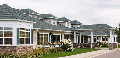 Exterior view of Prairie Senior Cottages: row of cottages with porches, white siding, and flowers.