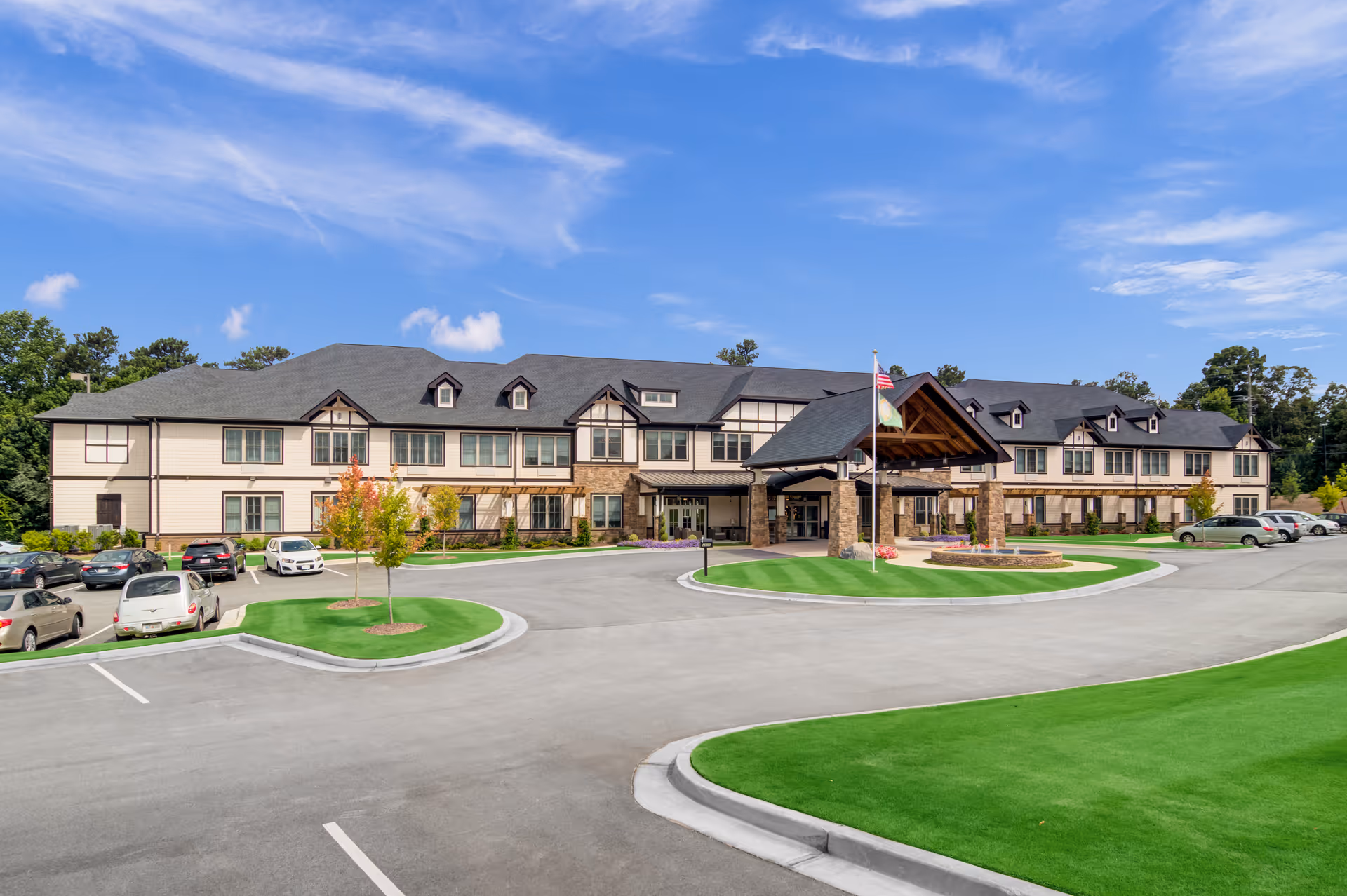 Exterior view of Oaks at Douglasville senior living facility with circular drive and parking.
